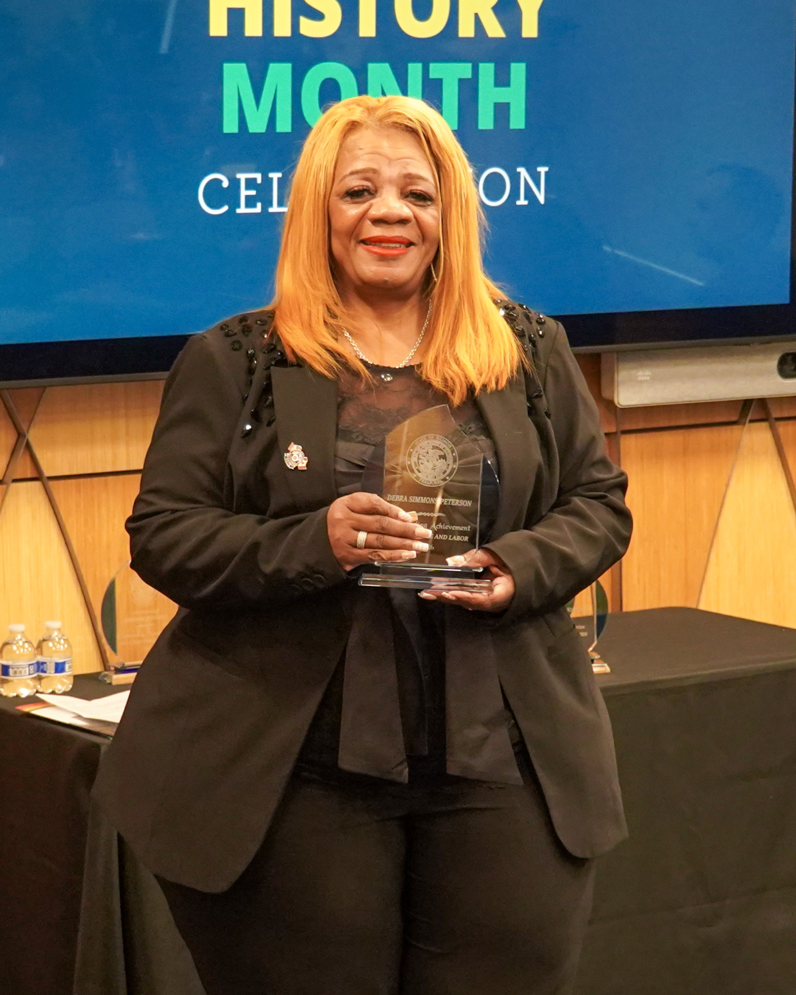 Debra Simmons-Peterson with award at Treasurer Frerichs' Black History Month Celebration