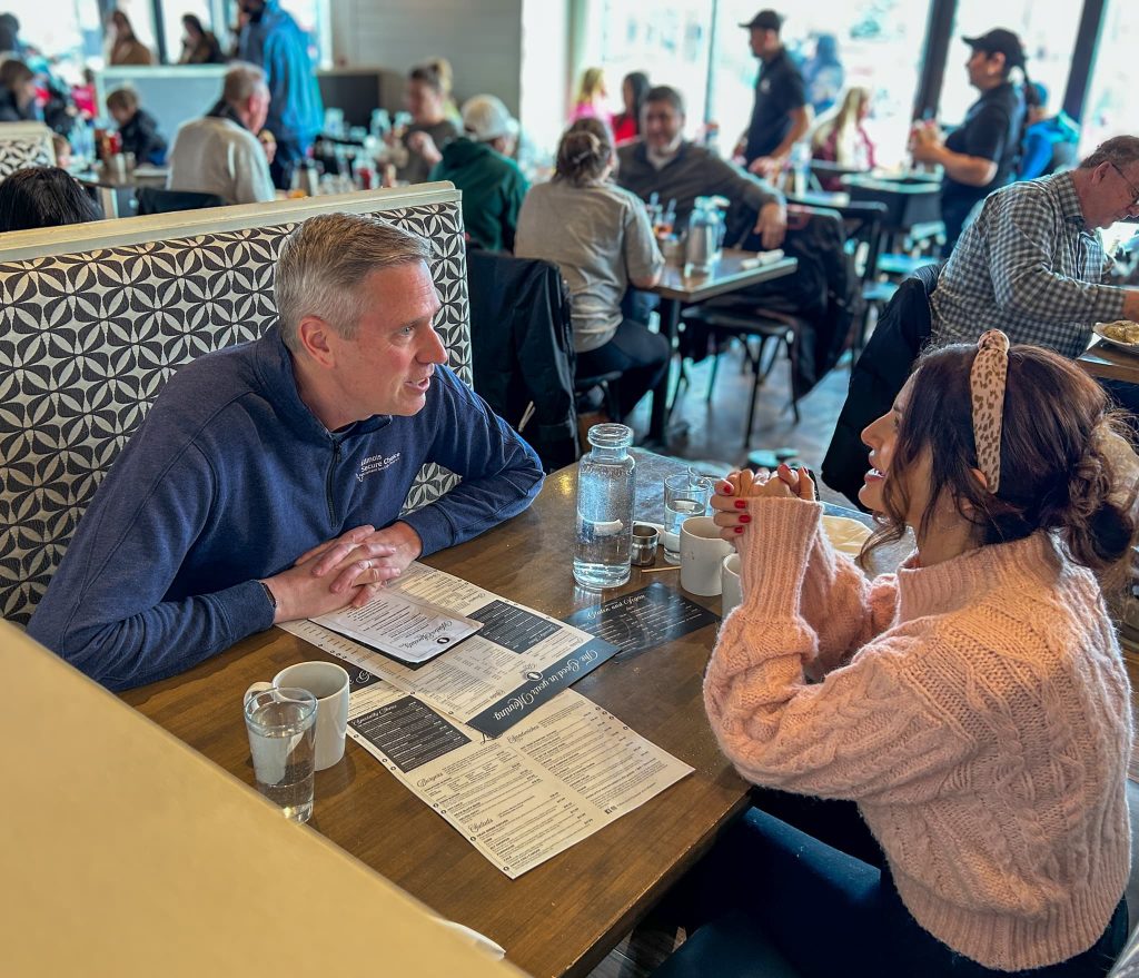 a man and a woman sitting at a diner having a conversation