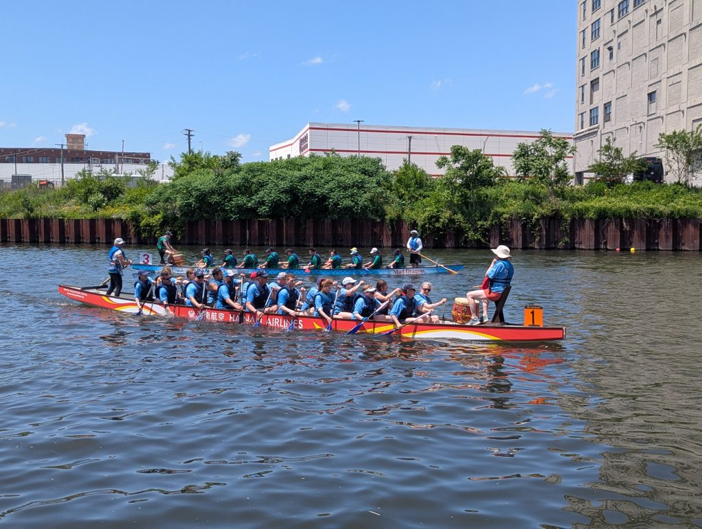 two long slender boats with crew on board race in the chicago river