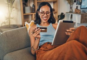 woman making an online payment with a credit card at home