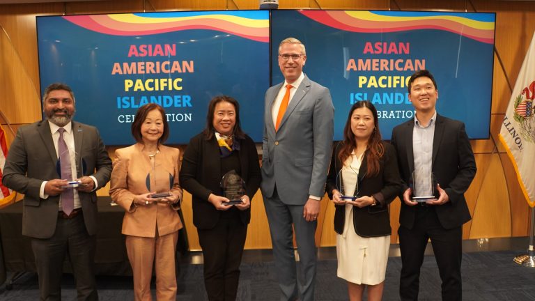 five award winners standing with a public official holding their awards